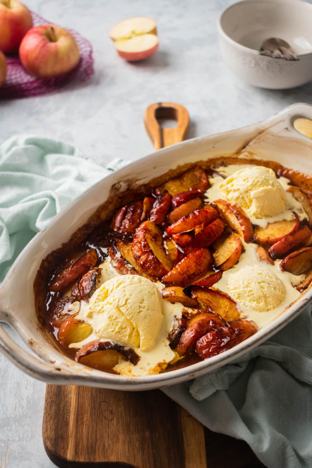 Brown sugar baked apples with cinnamon and vanilla ice cream with whole apples on the side.