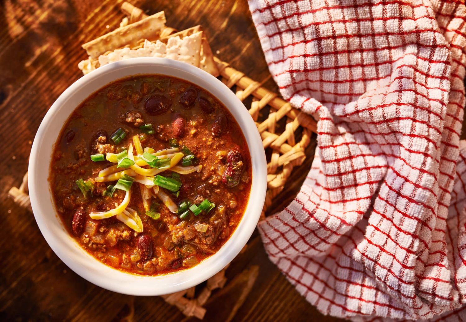 Easy Beef chili recipe in a bowl with a checkered napkin and crackers..