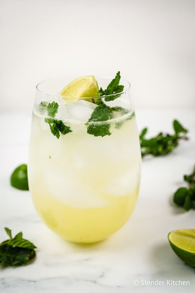 Mint mojito with lime juice, white rum, club soda, and muddled mint in a glass.