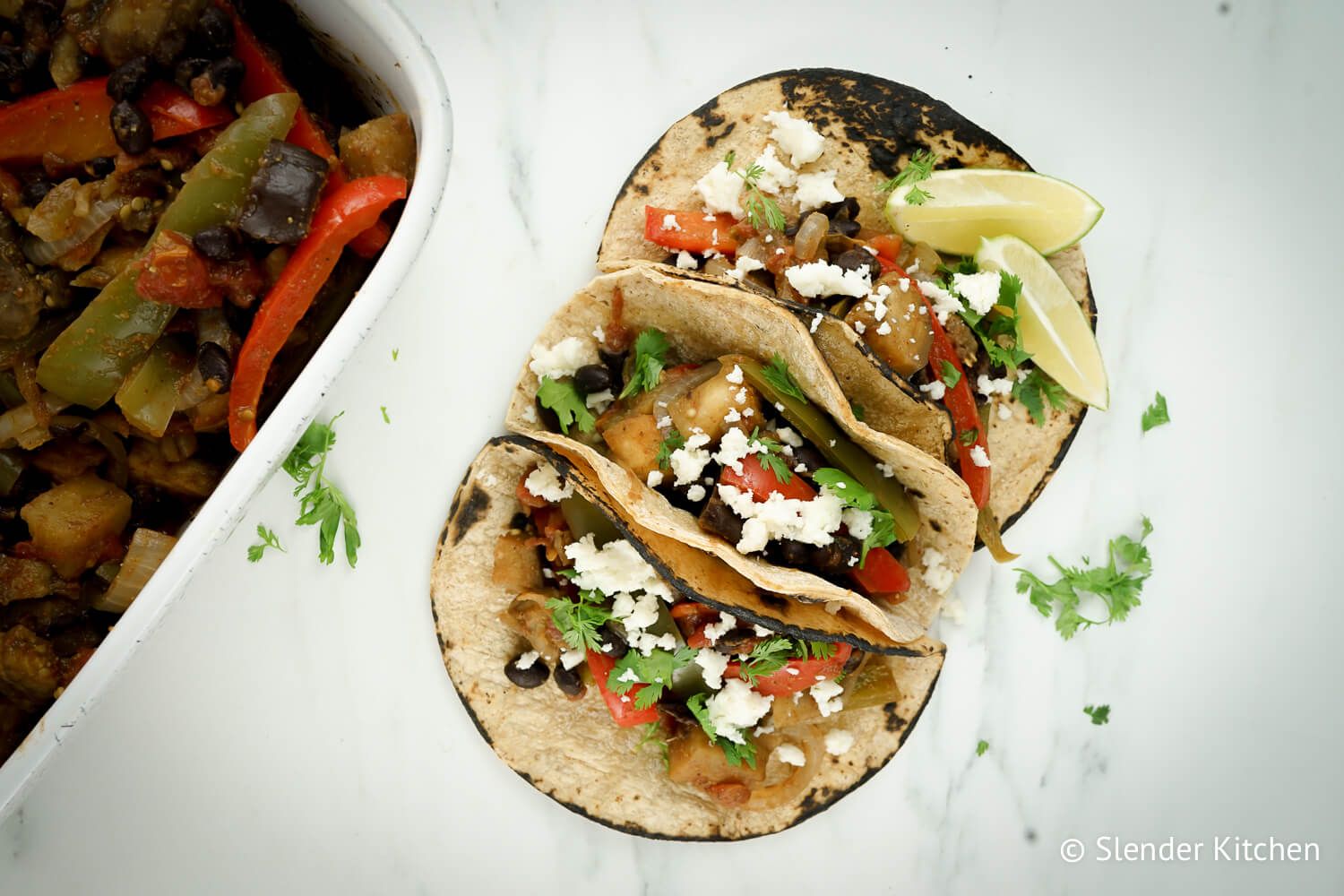 Eggplant fajitas in corn tortillas with black beans, eggplant, peppers, onions, and tomatoes.