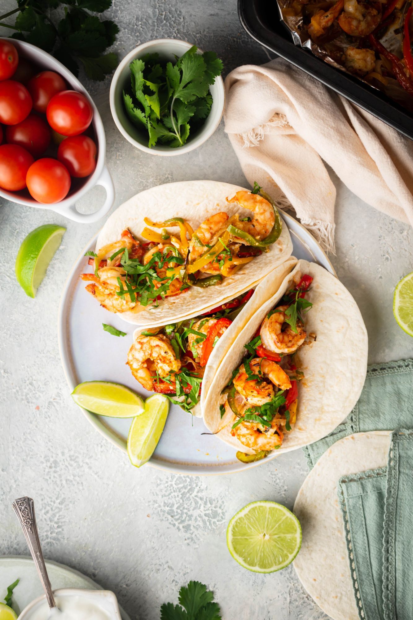 Shrimp fajitas with seasoned shrimp, bell peppers, onions, cilantro, lime juice, tomatoes, and cilantro. 