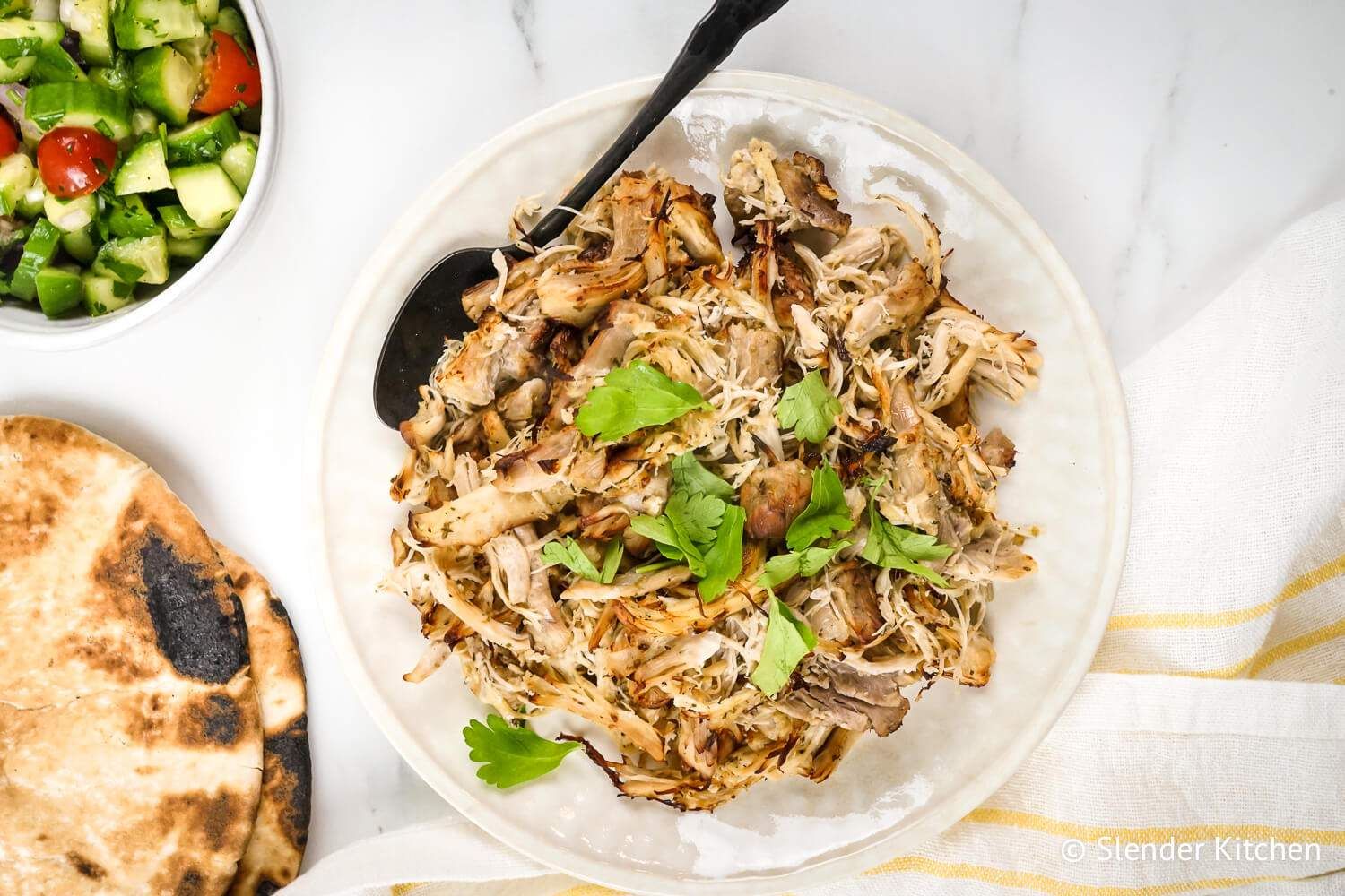 Greek chicken made with frozen chicken on a plate with rice and salad.