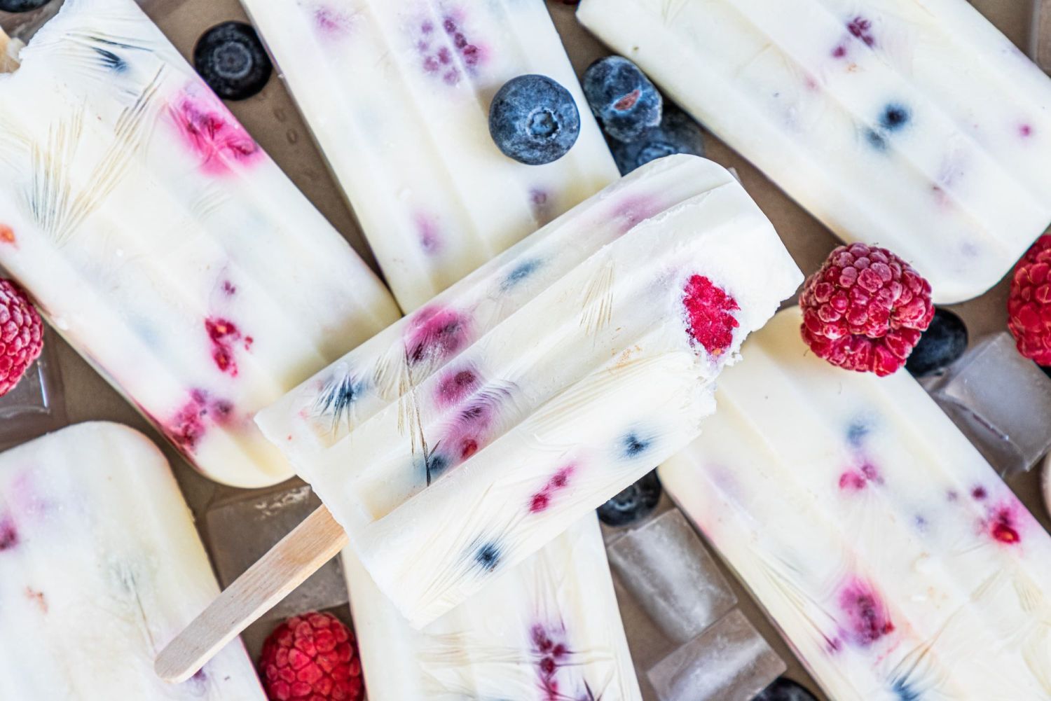 Homemade yogurt and fruit popsicles with blueberries and raspberries. 