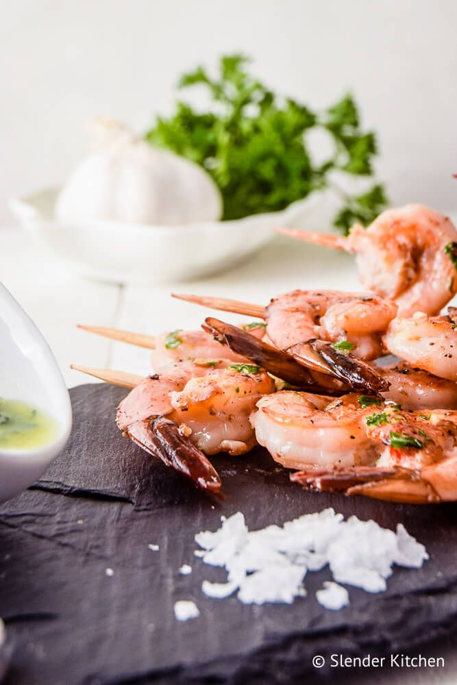 Shrimp kabobs with lemon, garlic, and parsley on skewers.