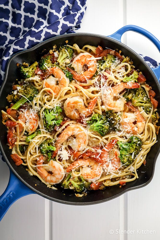 Shrimp and Broccoli pasta with lemon and garlic in a skillet with a blue napkin.