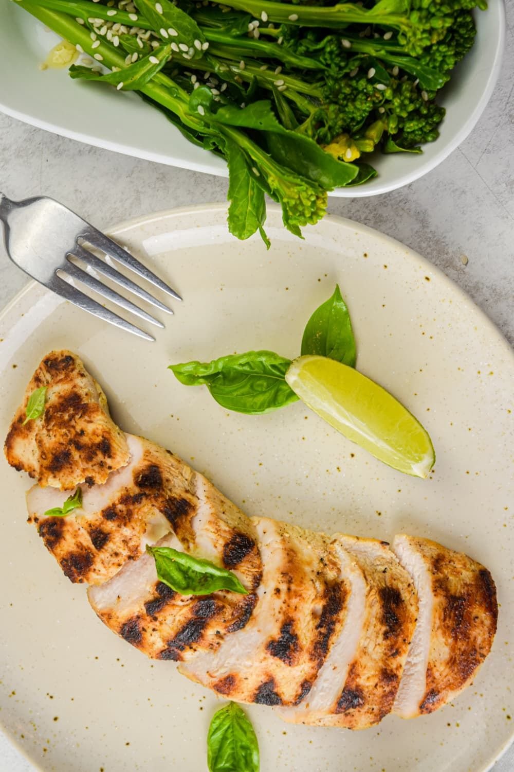 Basil Lime Chicken that has been grilled with broccolini, limes, and basil on the  side.