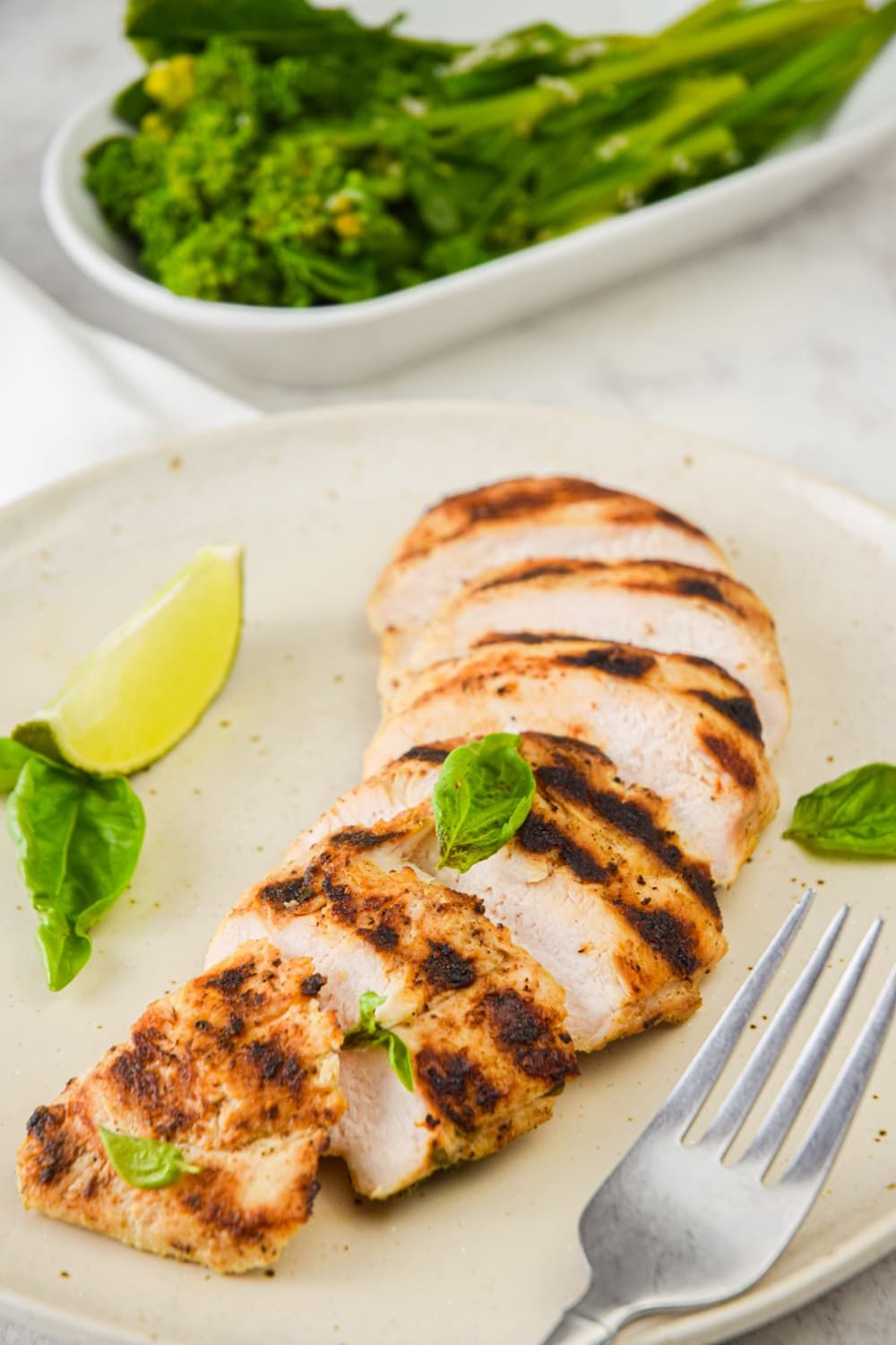 Grilled chicken marinated in basil and lime with broccolini on the side.