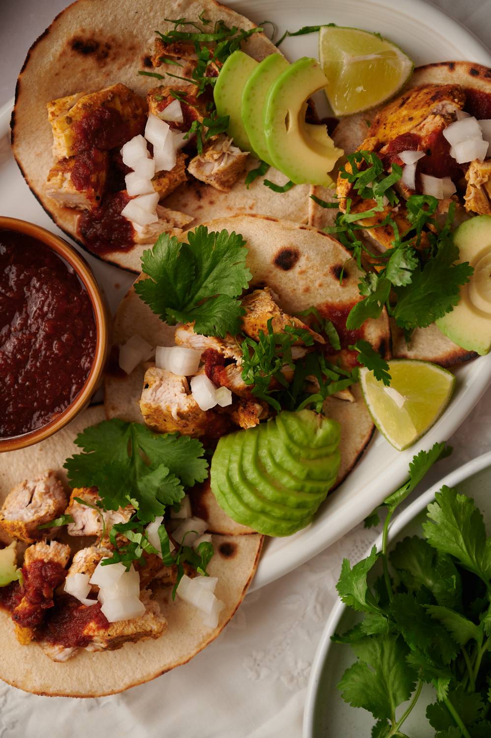 Chicken tacos with grilled chicken, avocado, cilantro, diced onions, and avocado.