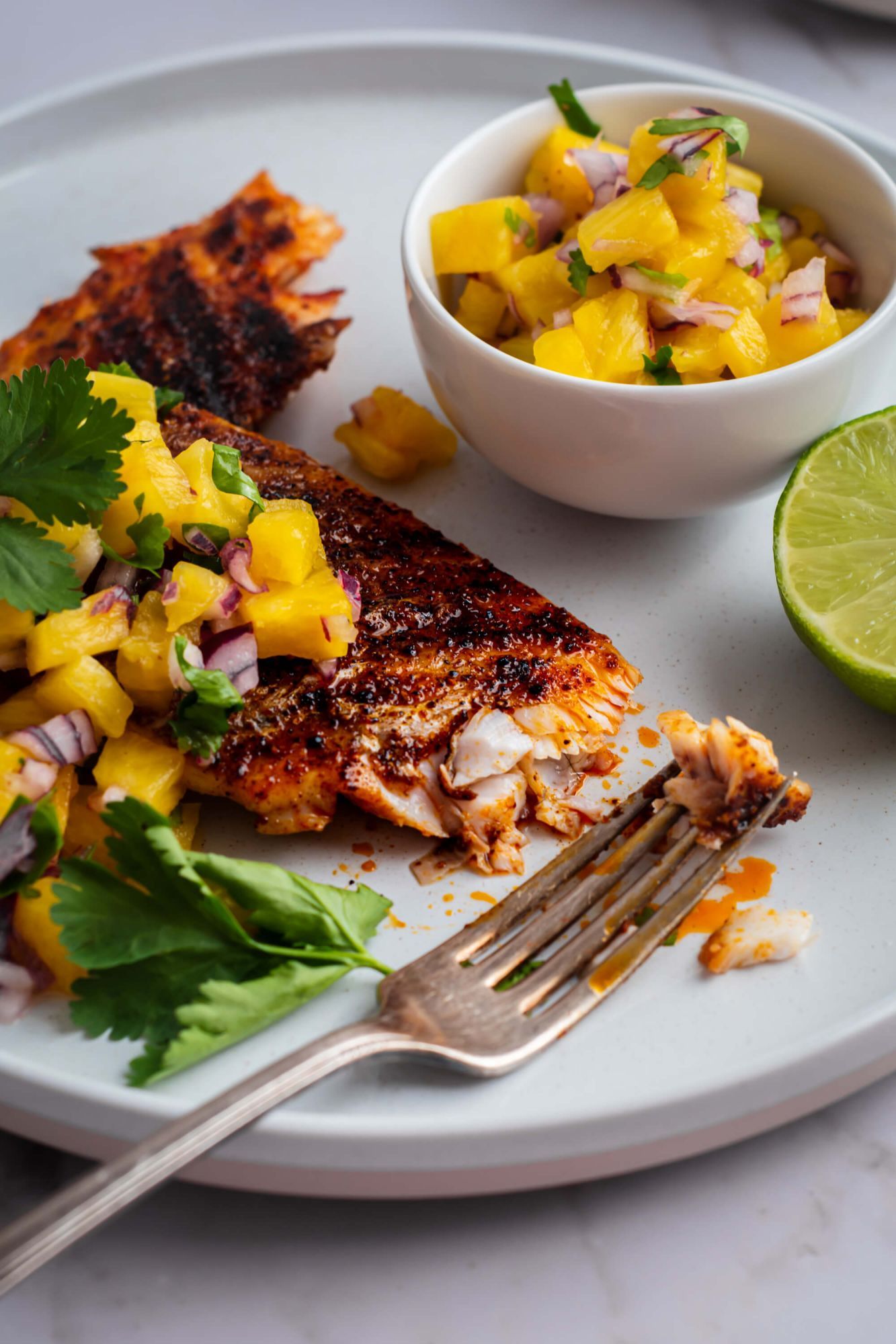 Mahi Mahi that has been grilled served with pineapple cilantro salsa on top.