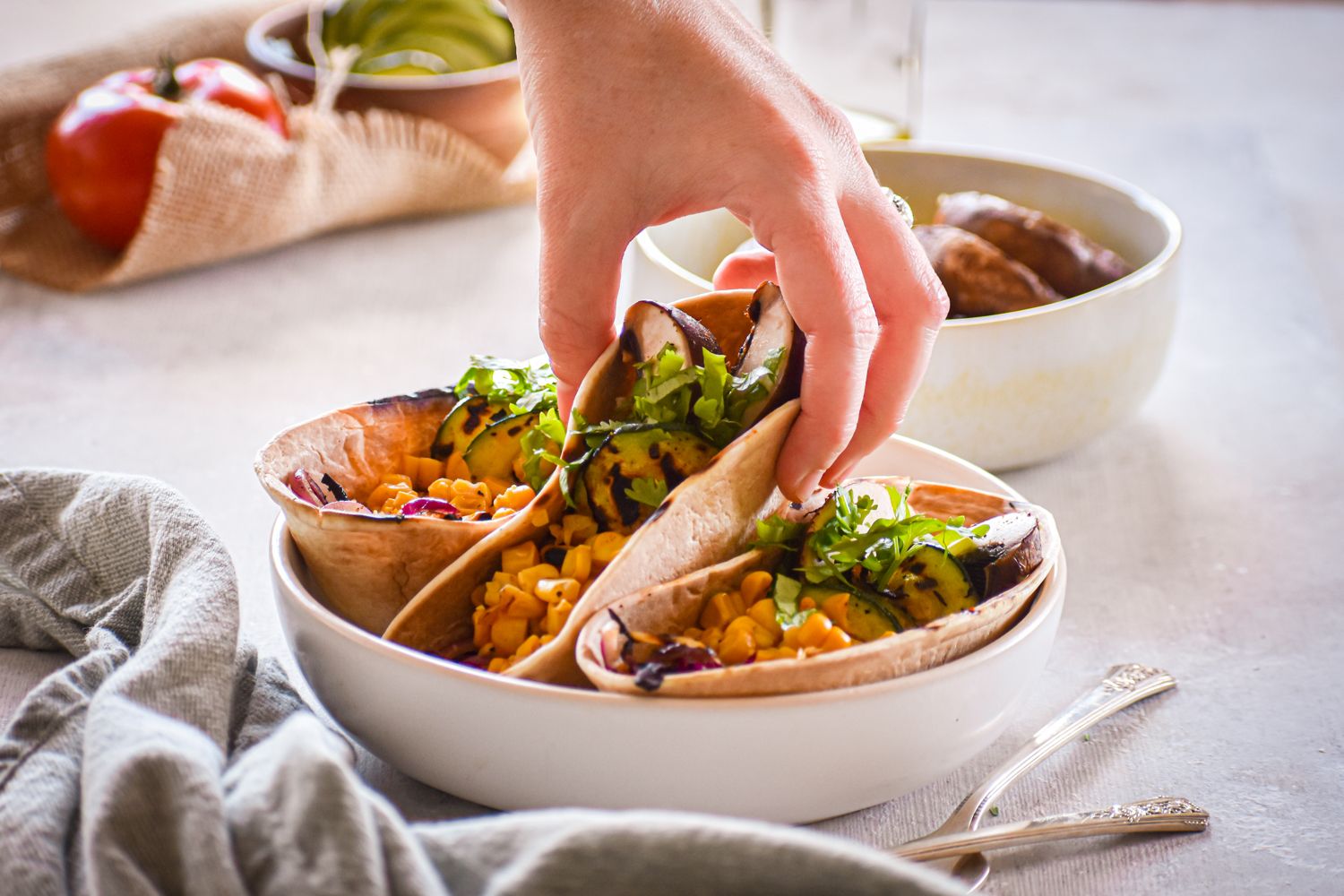 Grilled vegetable tacos that were grilled with corn, mushrooms, and zucchini in tortillas with tomatoes and cilantro.