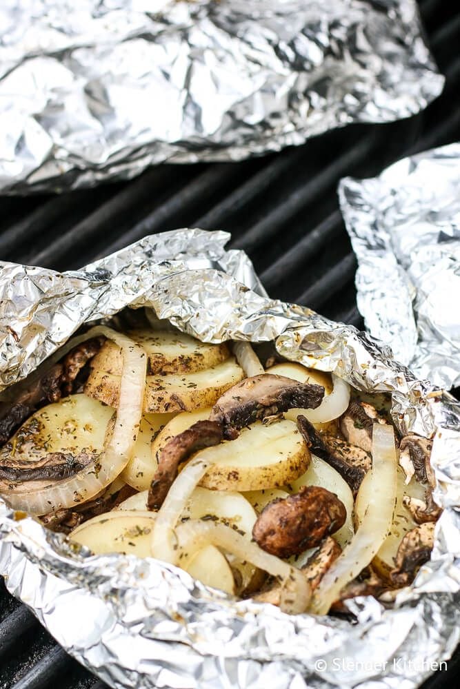 Grilled potatoes and onions in a foil packet on the grill.