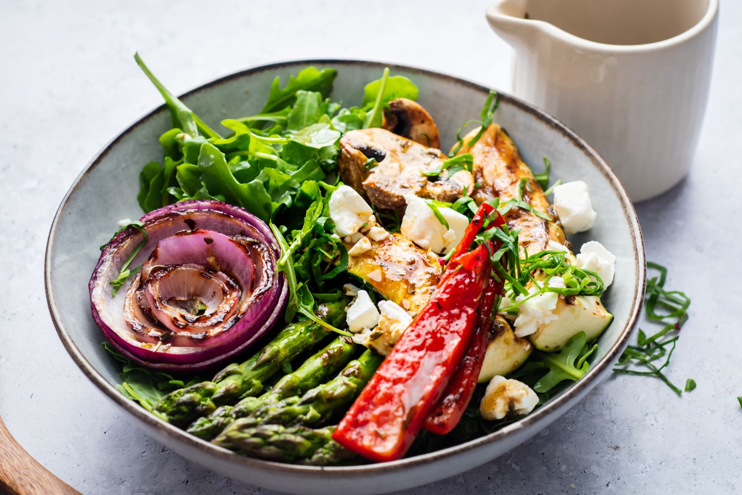 Fresh vegetable salad with grilled onions, asparagus, red bell peppers, zucchini, mushrooms, and feta cheese.