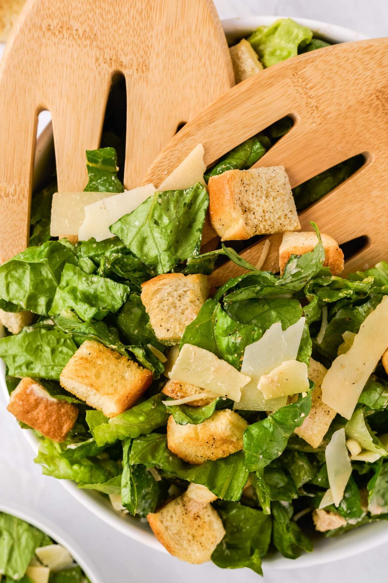 Lighter Caesar salad with Romaine lettuce, Parmesan cheese, croutons, and a yogurt Caesar dressing.