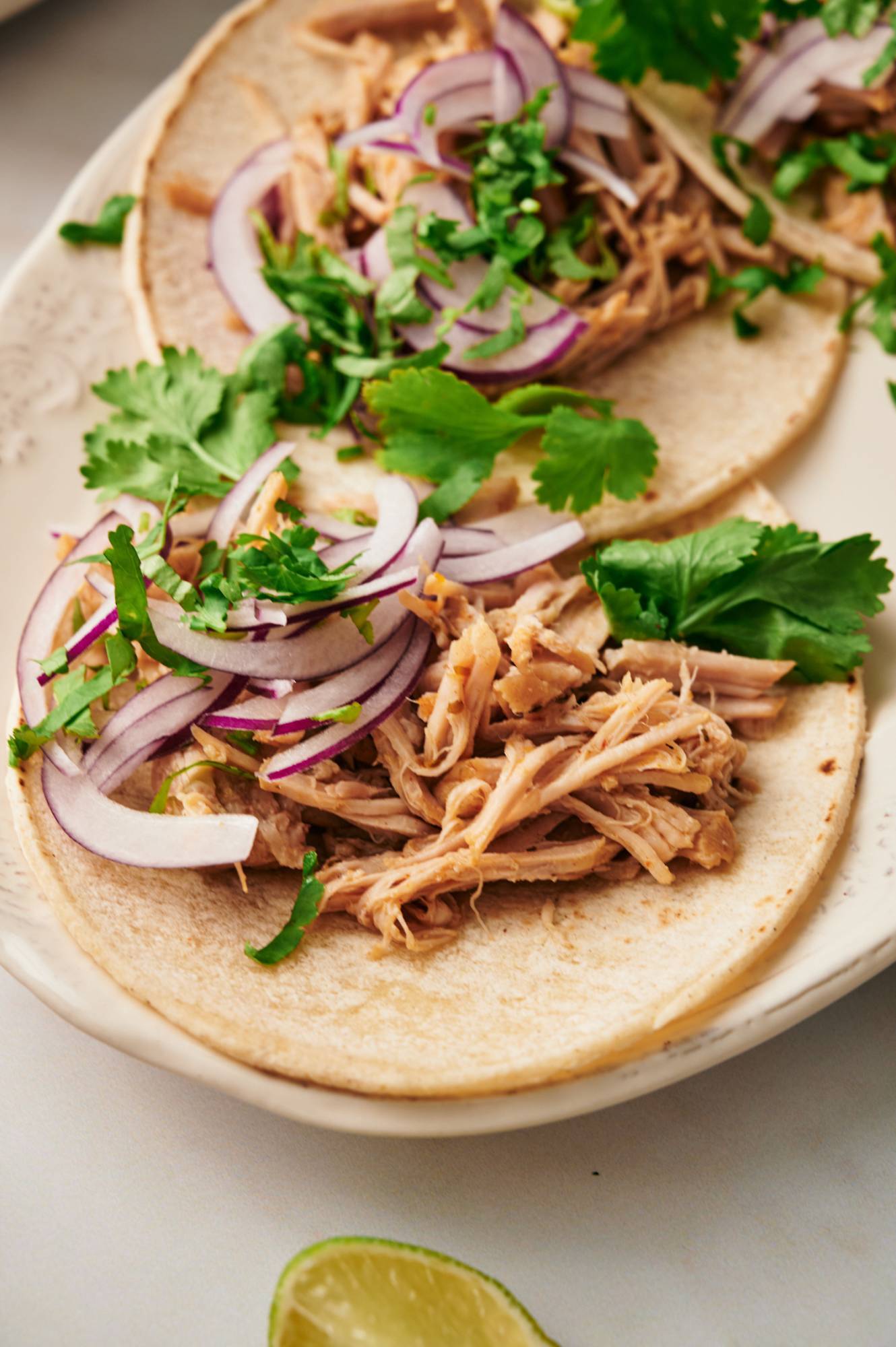 Carnitas tacos made with lean pork shoulder served in corn tortillas with red onion and cilantro.