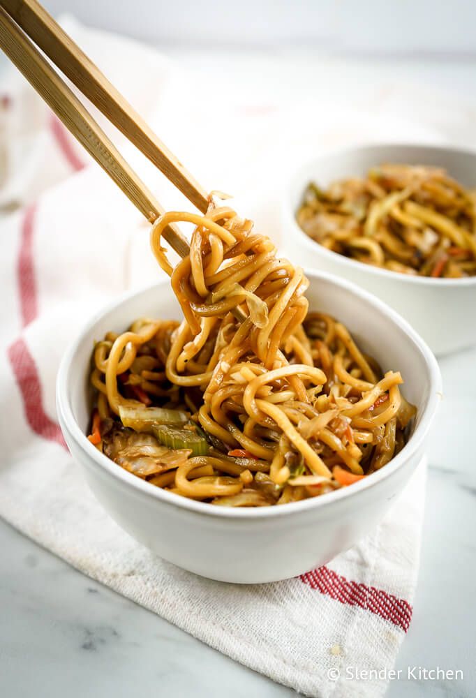 Healthy chow mein with cabbage, celery, and noodles in a bowl with chopsticks.