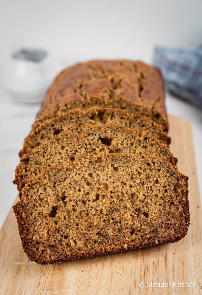 Healthy banana bread with cinnamon sliced on a wooden cutting board.