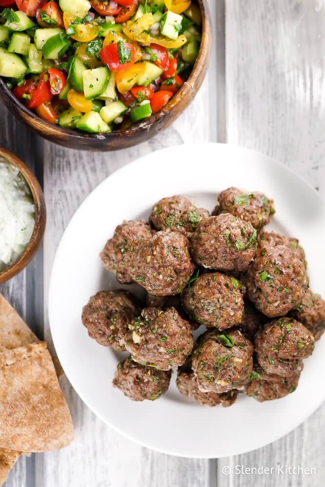 Greek meatballs with tomato and cucumber salad and tzatziki with pita bread.