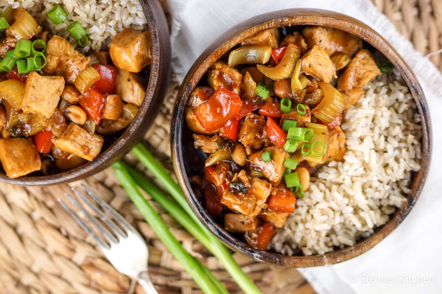 Healthy Kung Pao Chicken with brown rice in a wooden bowl.