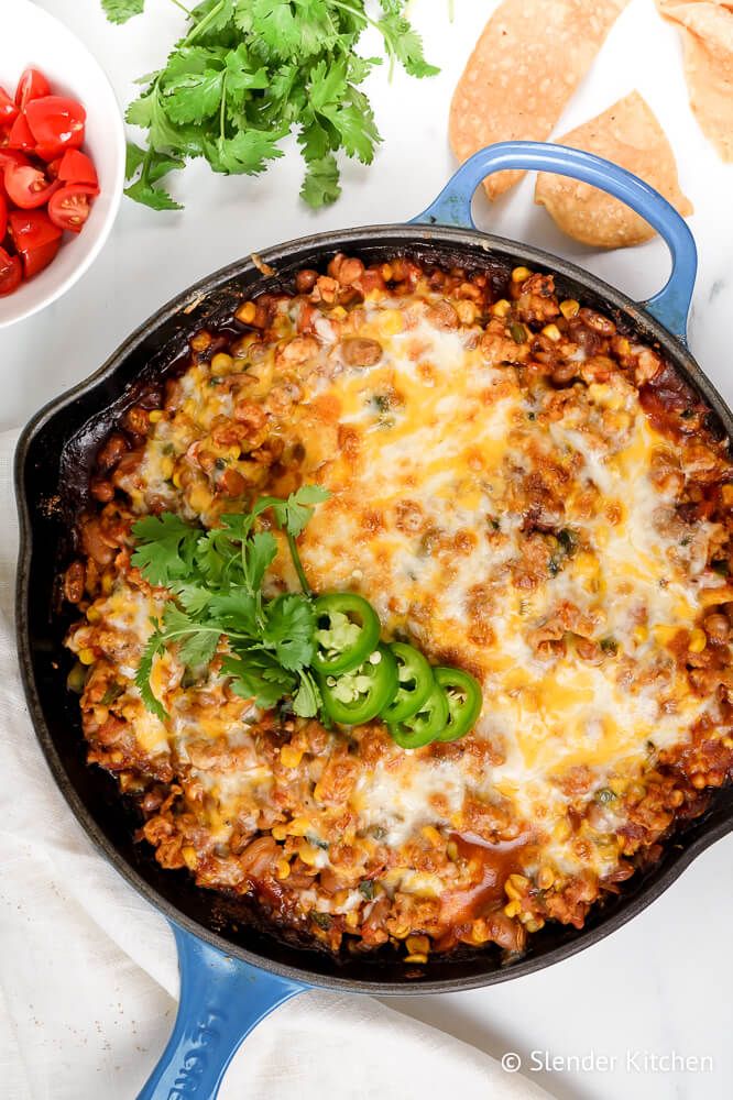 Taco Casserole with ground turkey, salsa, pinto beans, corn, and melted cheese in a skillet.