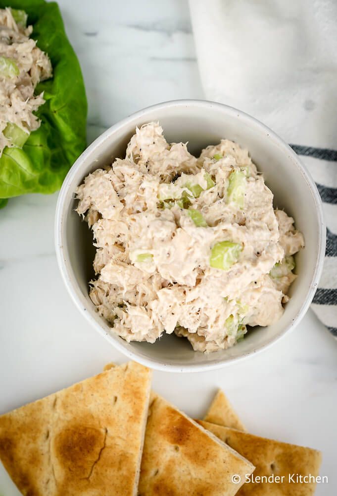 Healthy tuna salad on a lettuce wrap and in a bowl with pita bread.