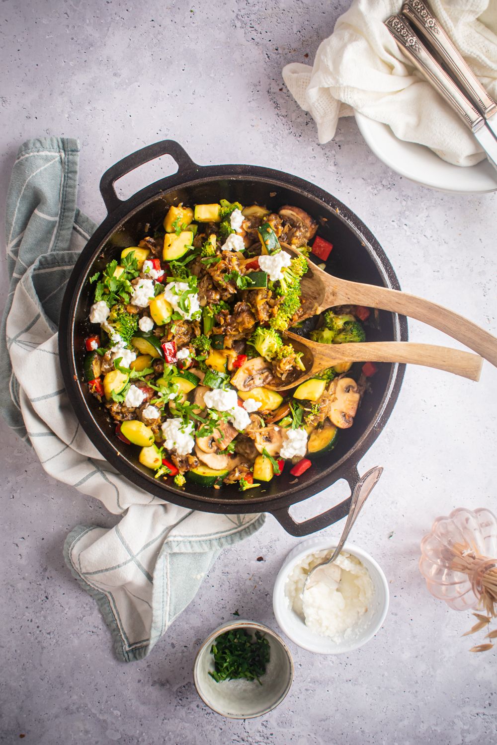 Skillet with vegetable hash with zucchini, hash brown potatoes, mushrooms, broccoli, and topped with feta cheese.