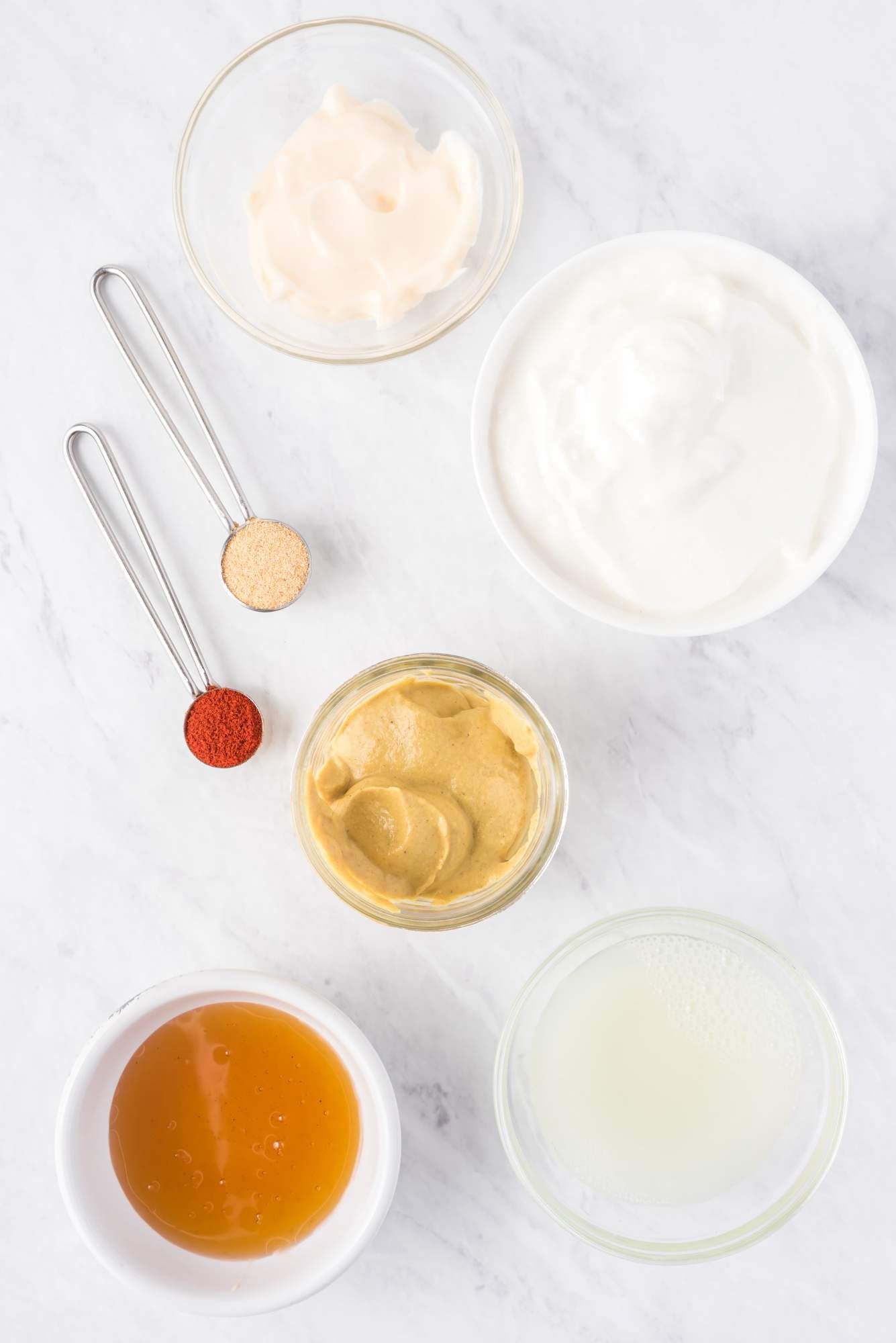 Ingredients for healthy honey mustard including Greek yogurt, mustard, honey, and paprika.