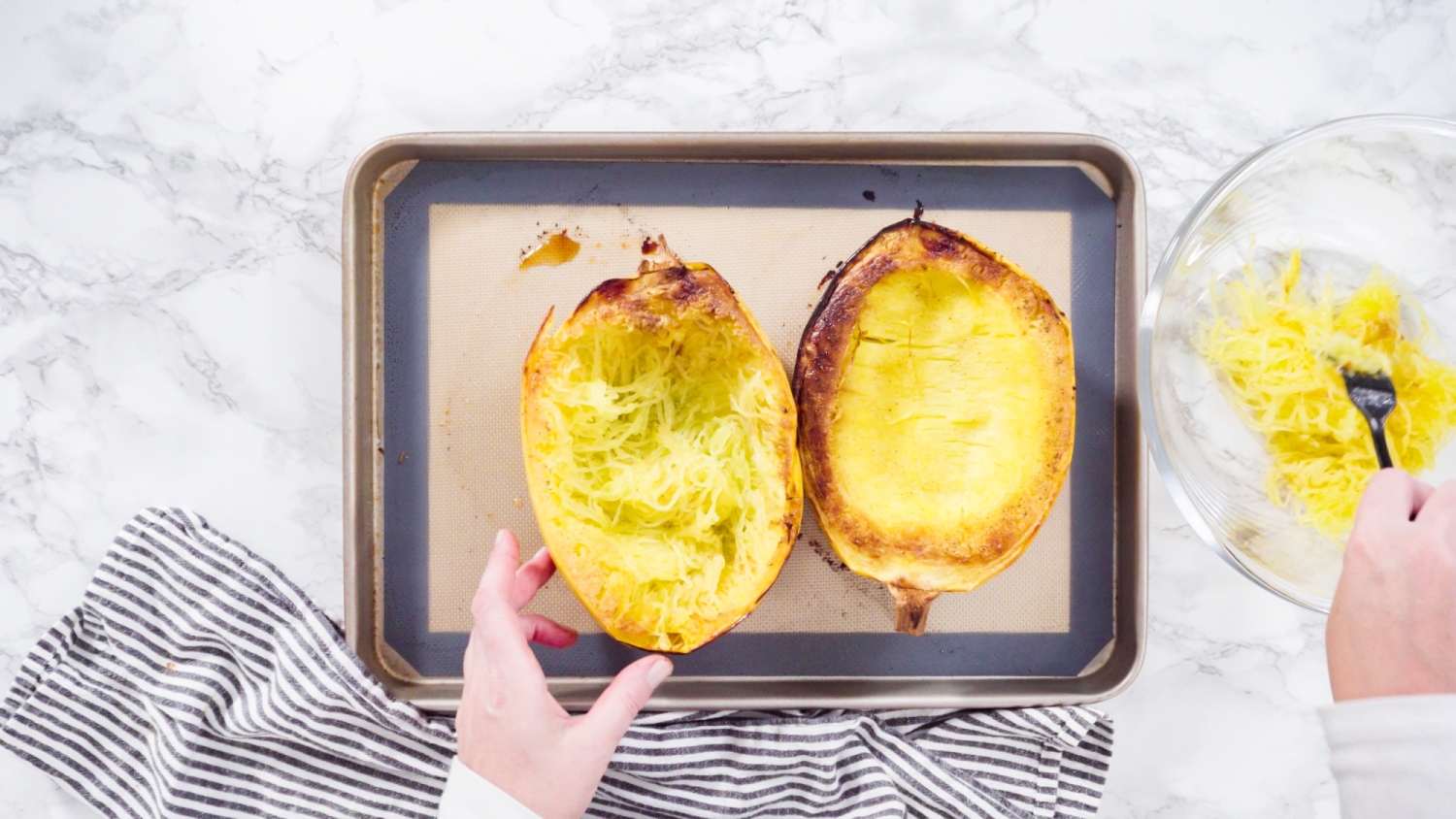 Roasted cooked spaghetti squash on a baking sheet with caramelized edges. 