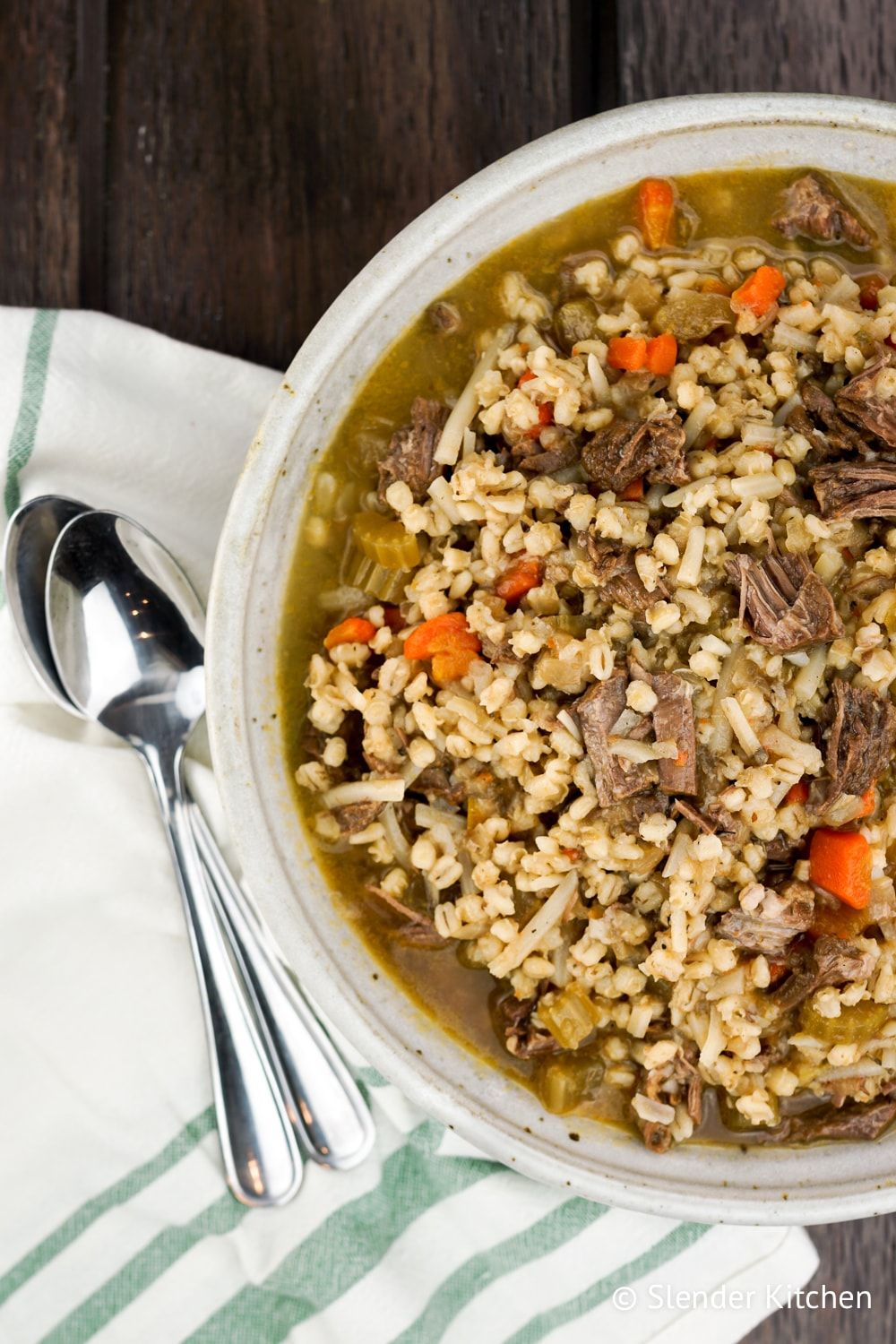 Beef and Barley Stew in a bowl with two spoons.