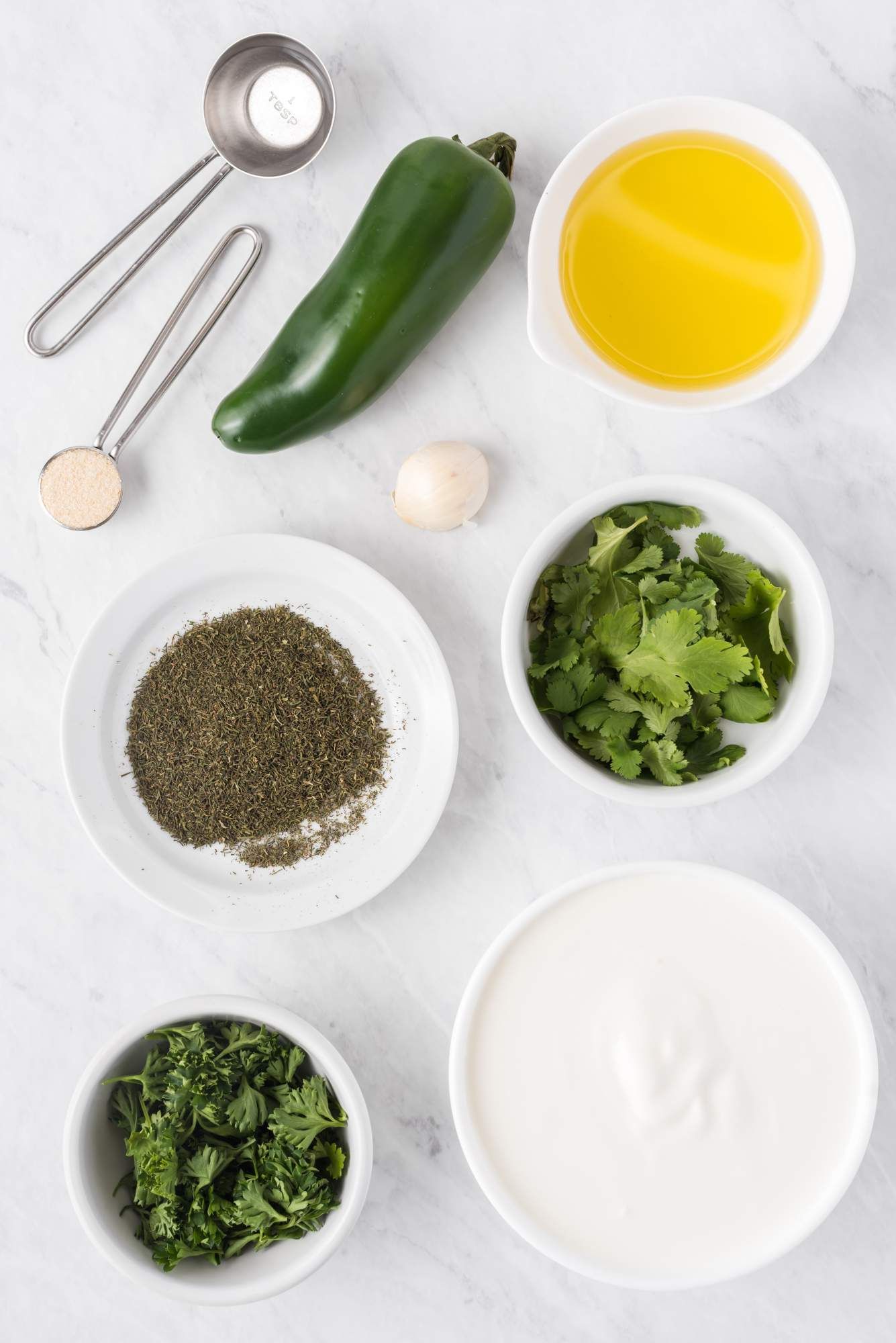 Jalapenos, olive oil, Greek yogurt, cilantro, parsley, and dill to make jalapeno ranch dressing.