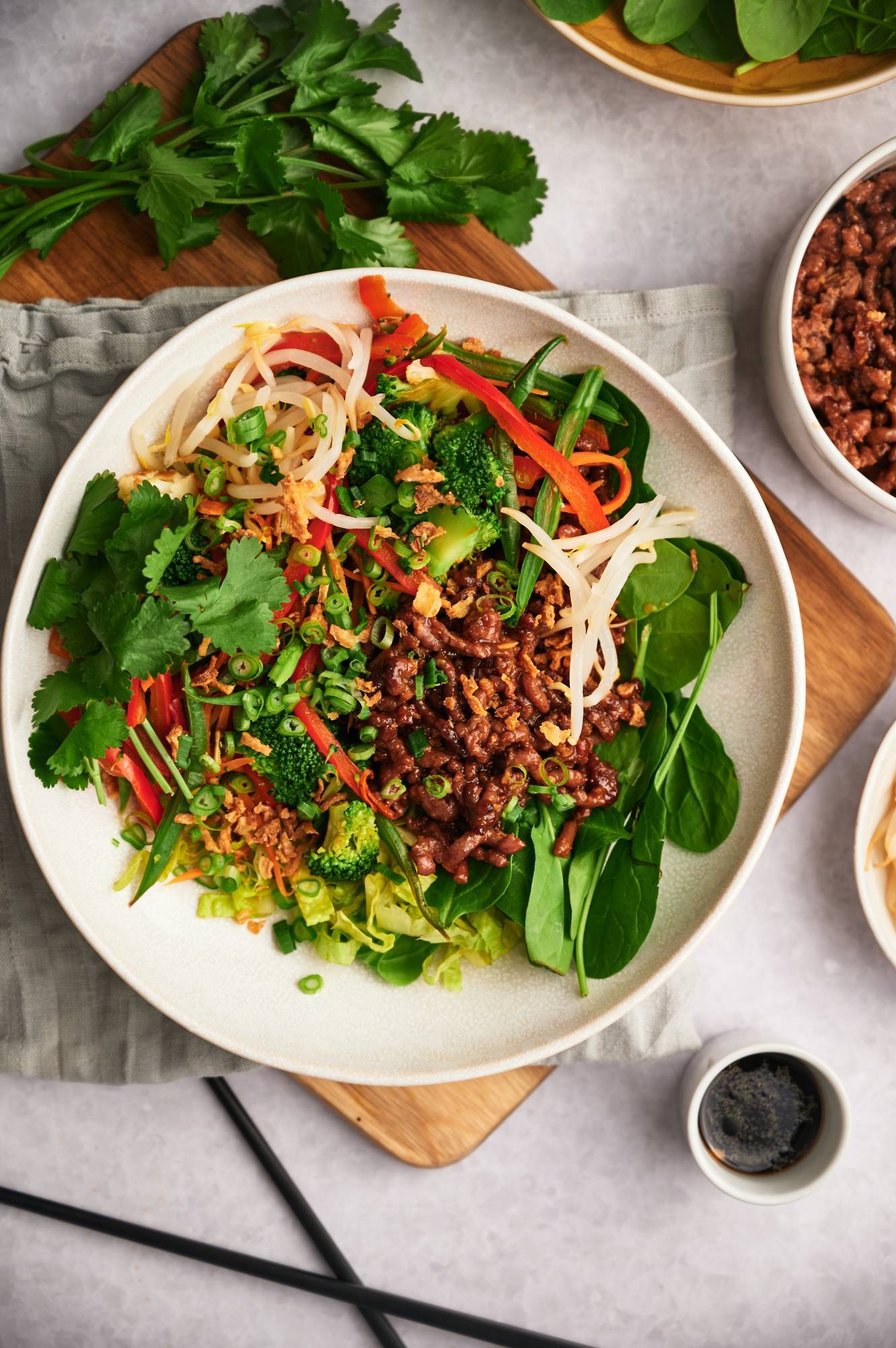 Korean inspired beef bowls served with rice, sprouts, green onions, lettuce, cilantro, and broccoli.