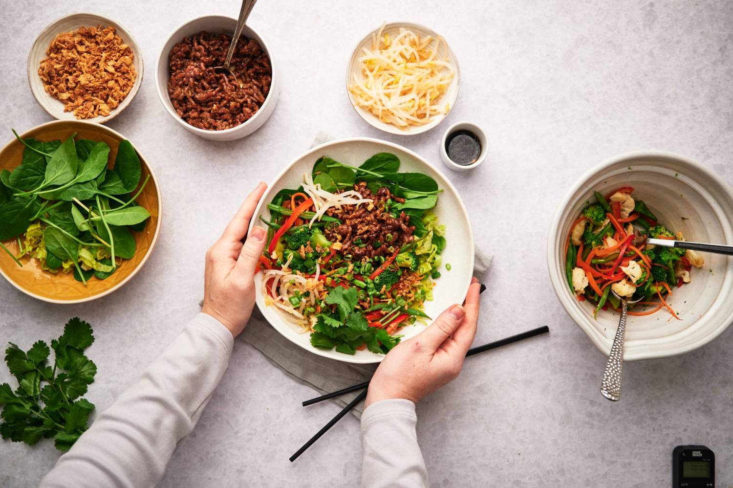 Easy Korean beef bowls with ground beef, vegetables, and rice in a bowl with toppings on the side.