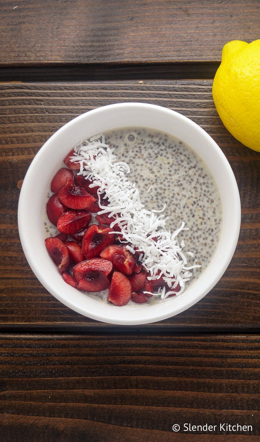 Chia pudding with lemon and cherries on a wooden table.