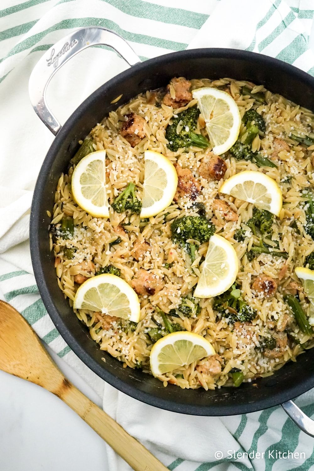 Lemon Orzo with broccoli and chicken sausage in a pan with wooden spoon.