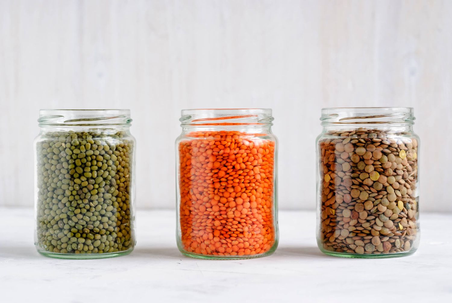 Four glass jars of different types of lentils.