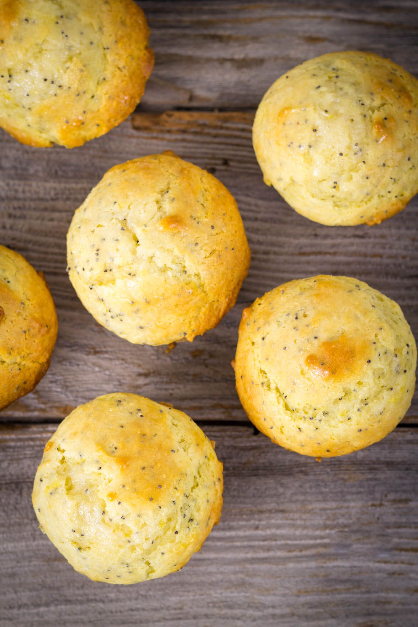 Low carb muffins with lemon and chia seeds on a wooden cutting board.