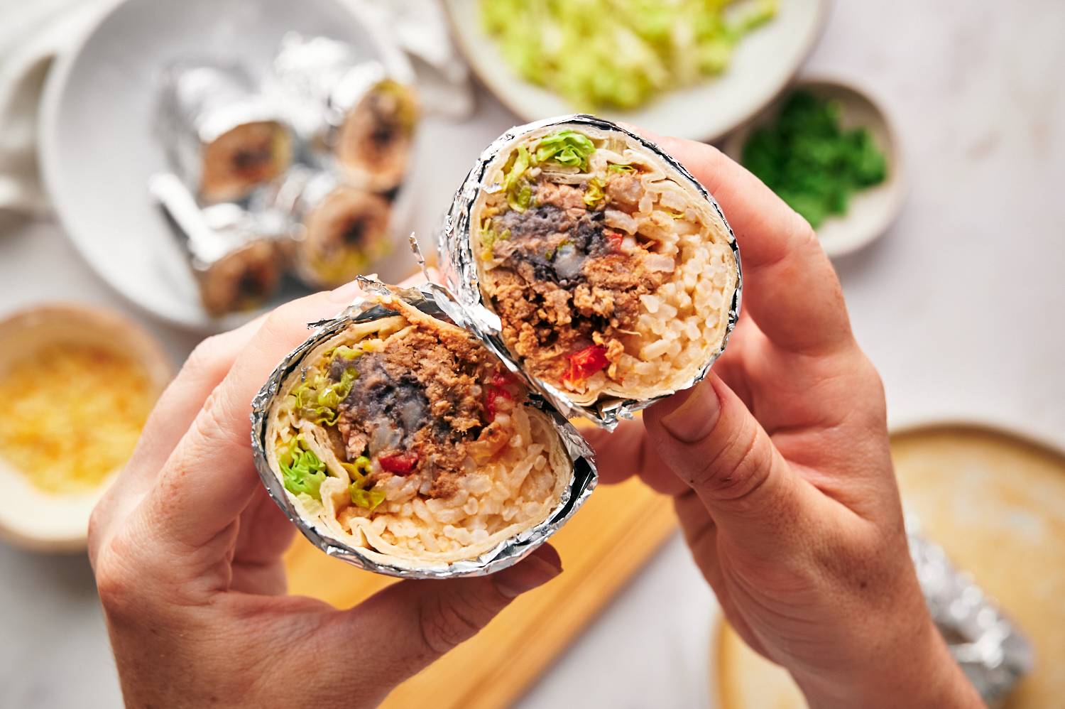 Homemade machaca burritos with beans, rice, cheese, lettuce, and salsa rolled in a flour tortilla and wrapped in foil.