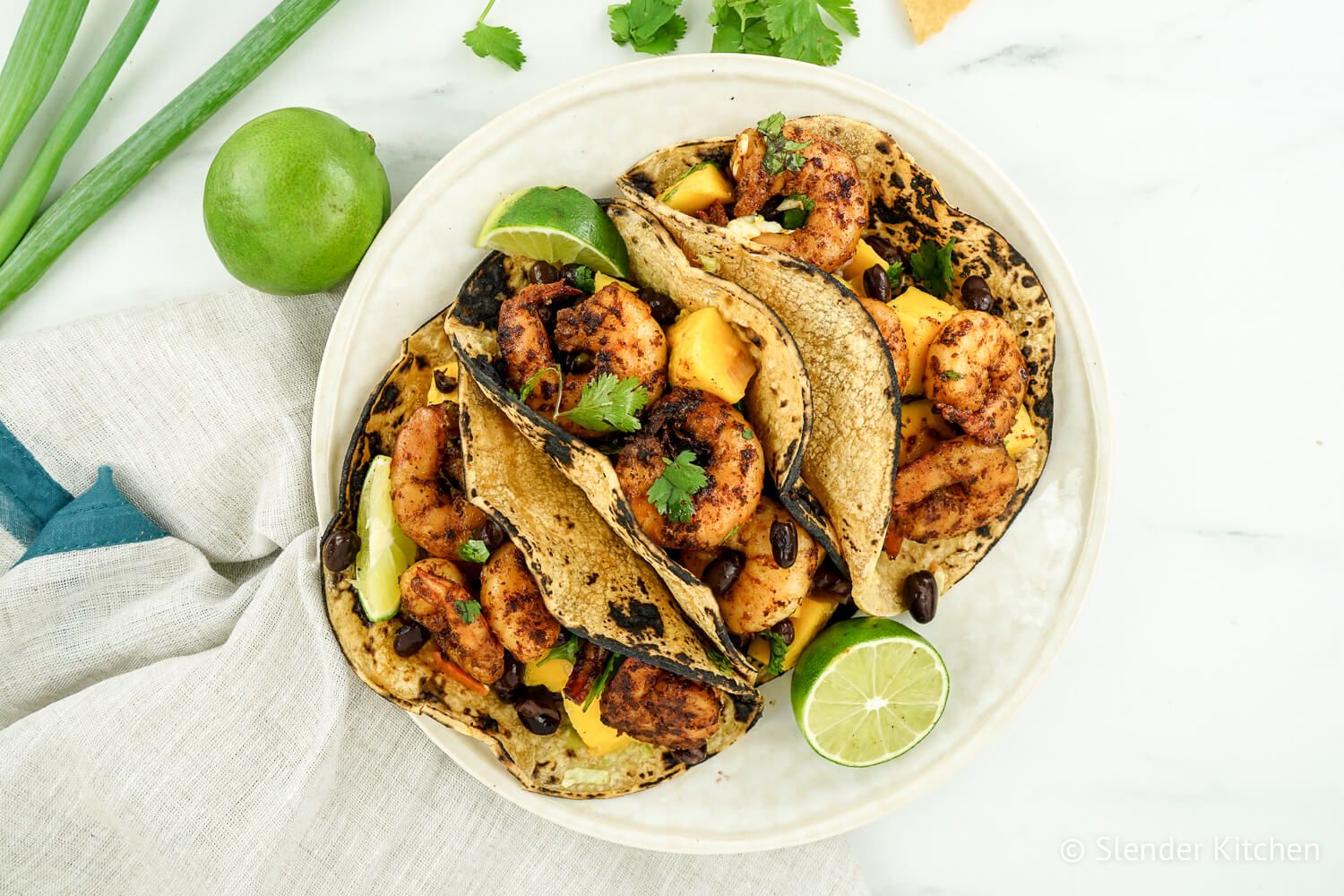 Shrimp tacos with mango salsa in corn tortillas.