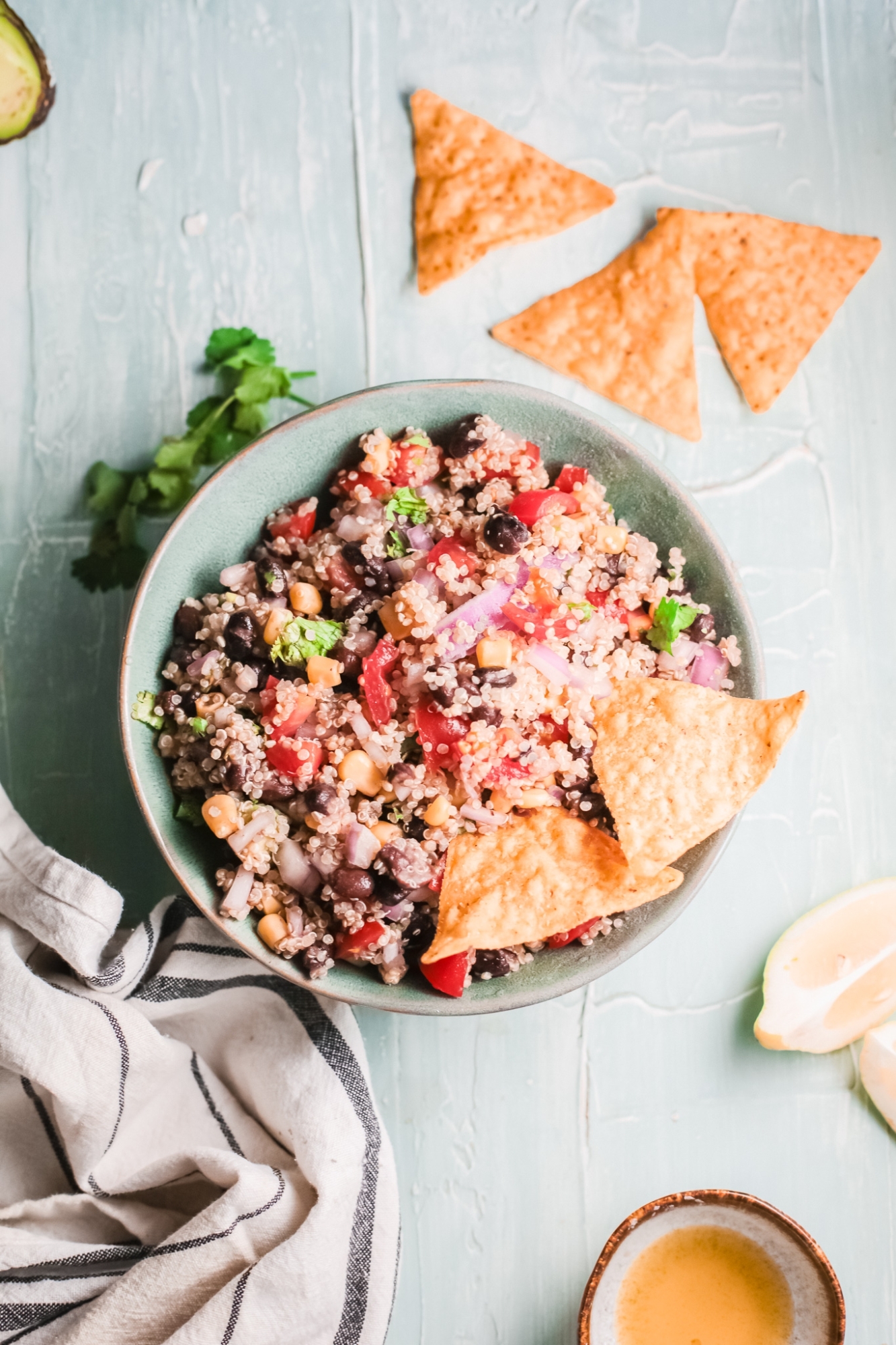 Quinoa with Mexican flavors including beans, tomatoes, taco seasoning, onions, peppers, and cilantro served with chips.