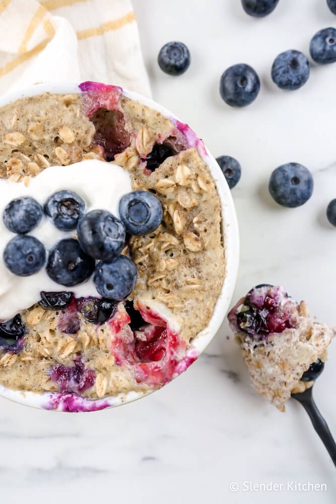 Microwave Muffin with blueberries, oatmeal, flaxseeds, and cinnamon in a mug with a napkin.