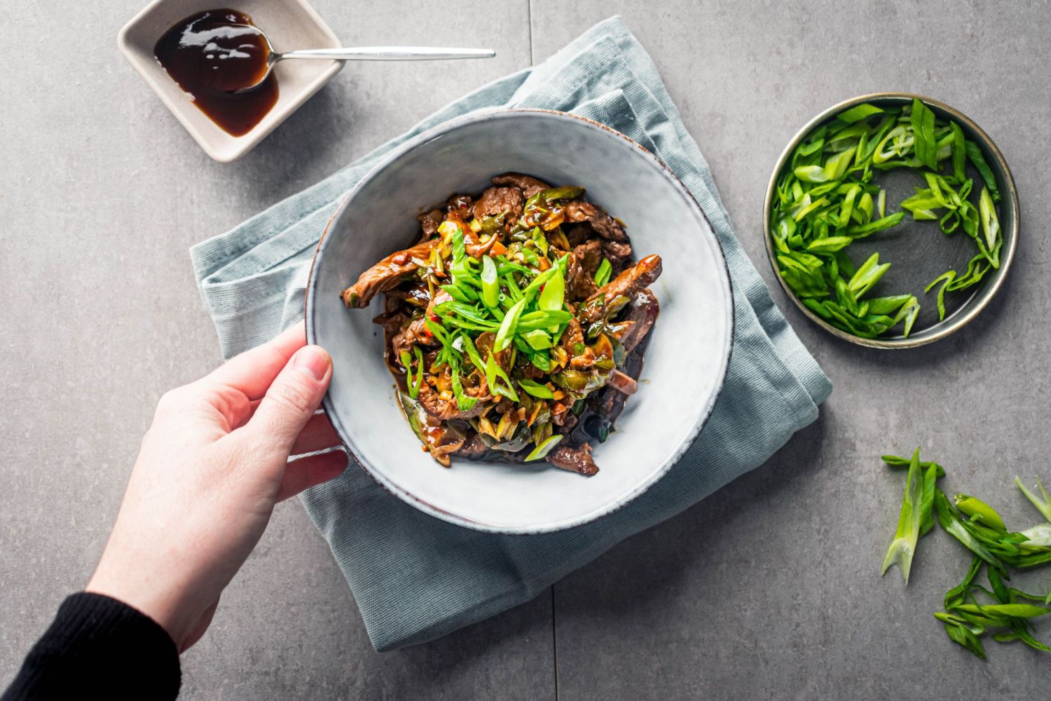 Stir fried beef in Mongolian sauce with thin slices of beef, Mongolian sauce, and sliced green onions.