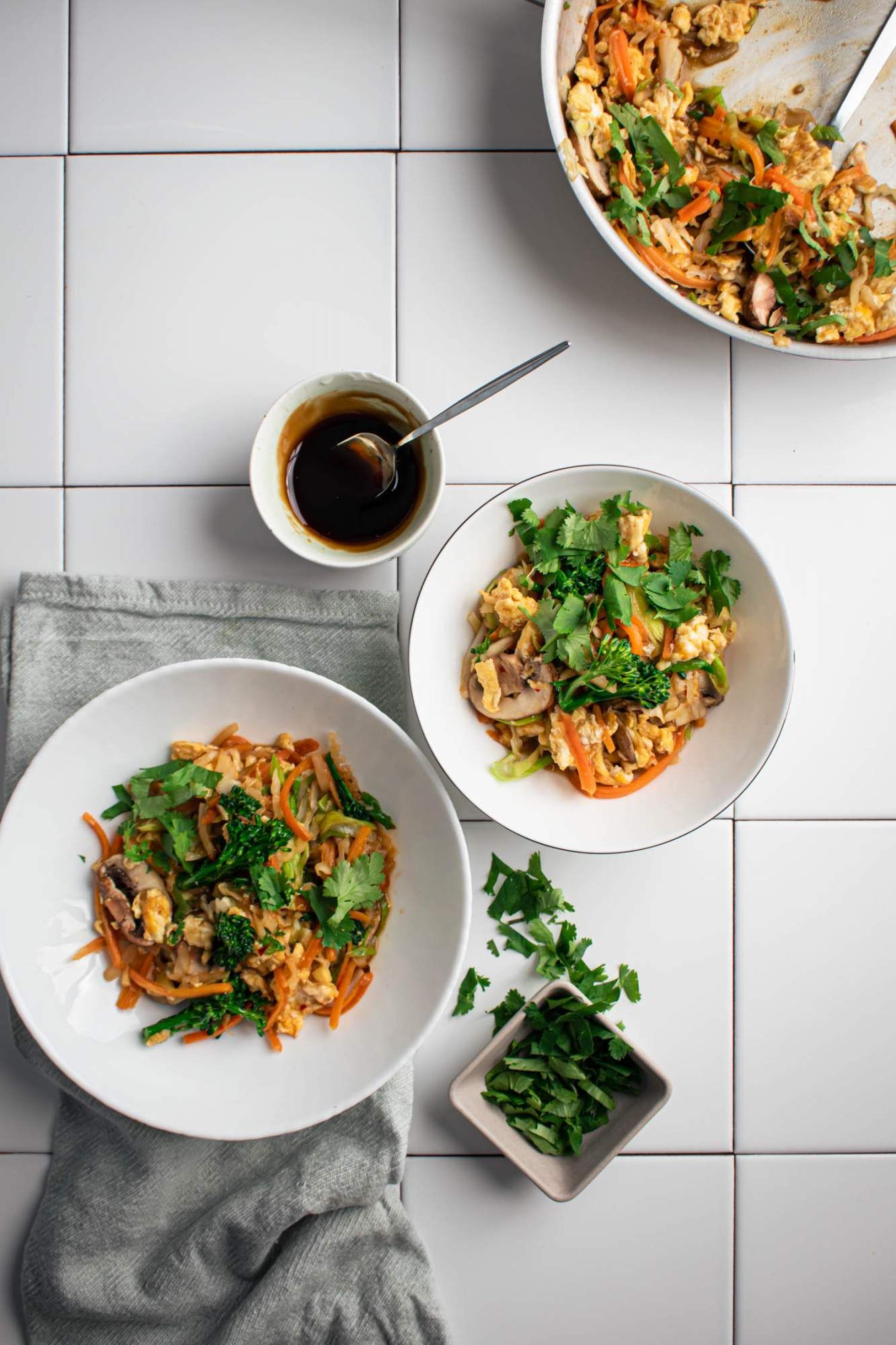 Chinese vegetables cooked in moo shu sauce in a bowl with moo shu sauce on the side.