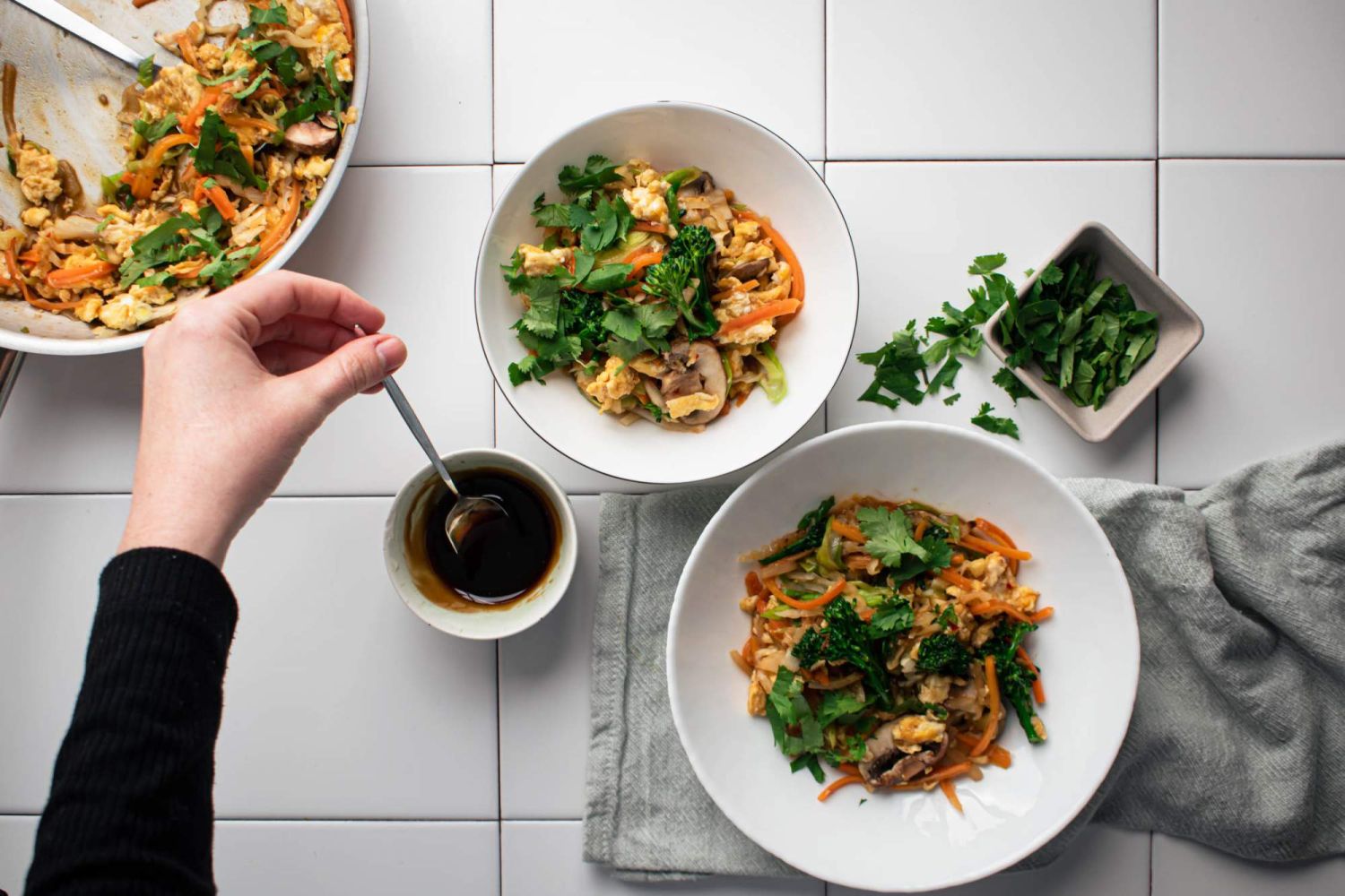 Moo shu stir fried vegetables in two bowls with cabbage, eggs, broccoli, and mushrooms.