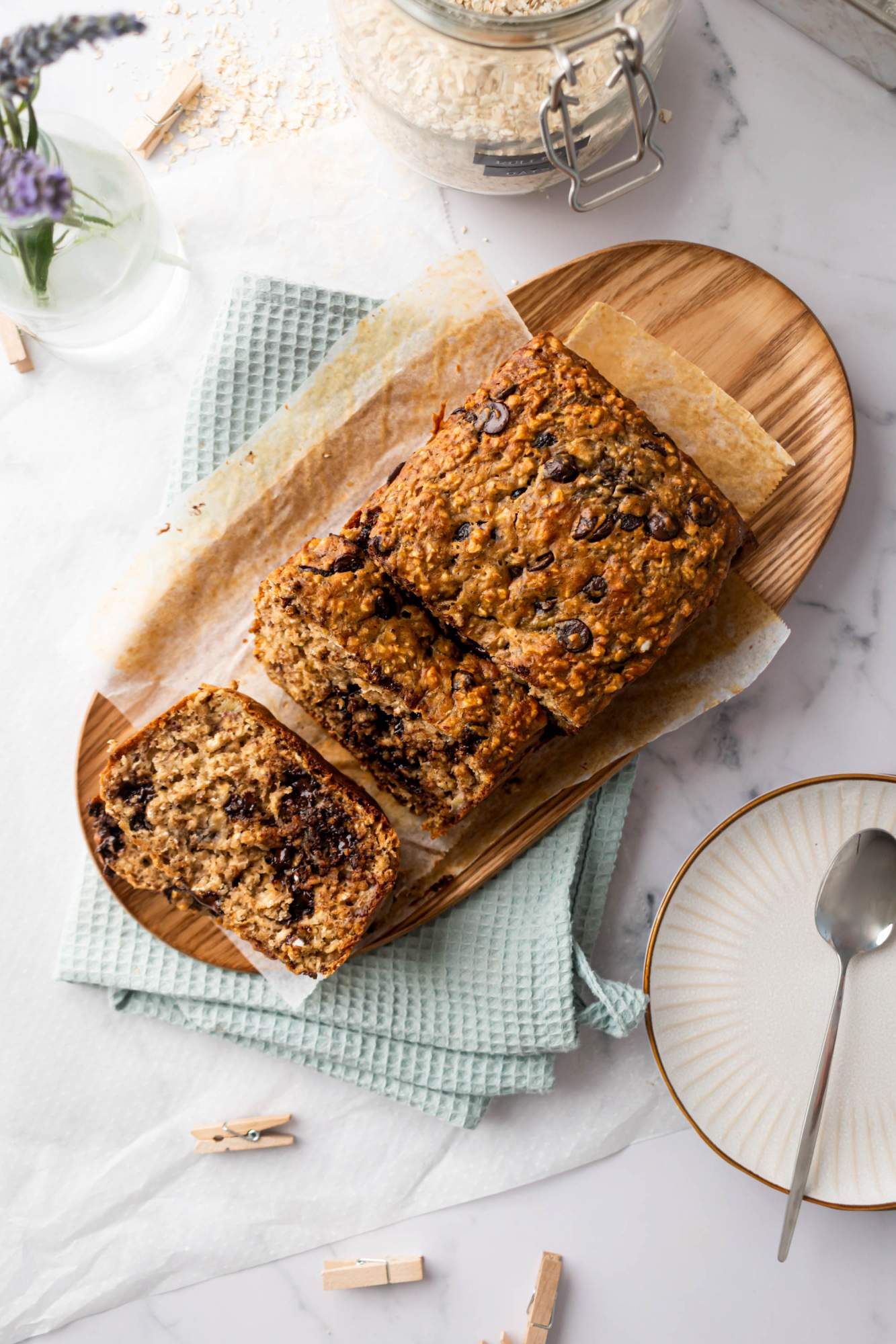 Chocolate chip banana oatmeal bread cut into slices on a wooden background.