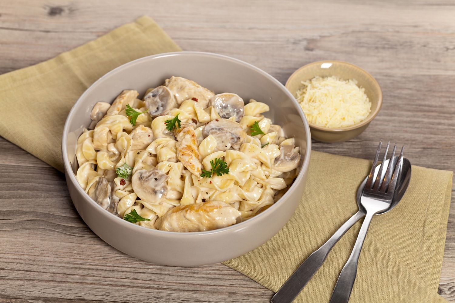 Healthy One Pot Chicken Mushroom Pasta in a dish with a wooden spoon.