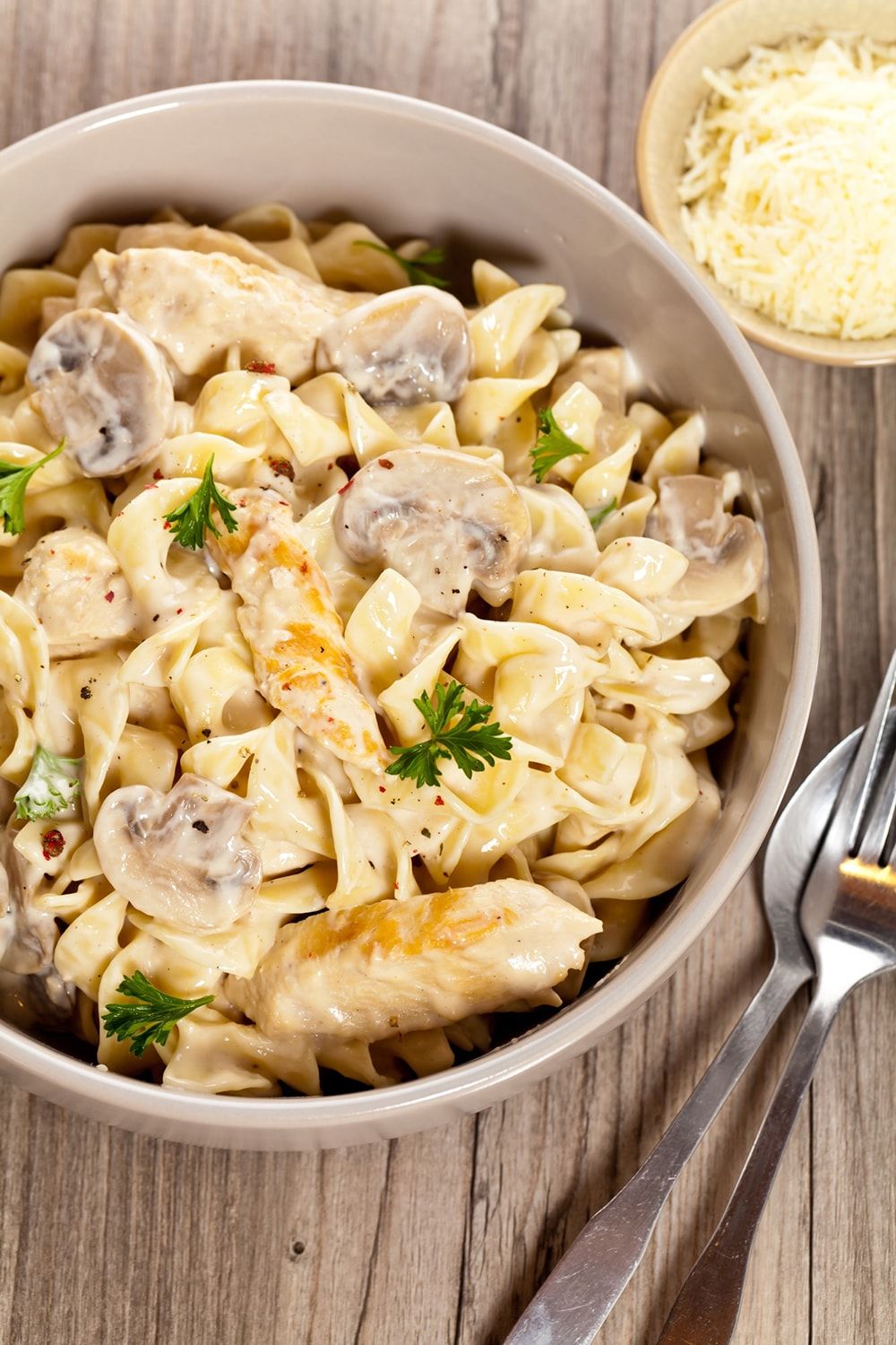 One Pot Chicken and Mushroom Pasta in a white bowl with basil.