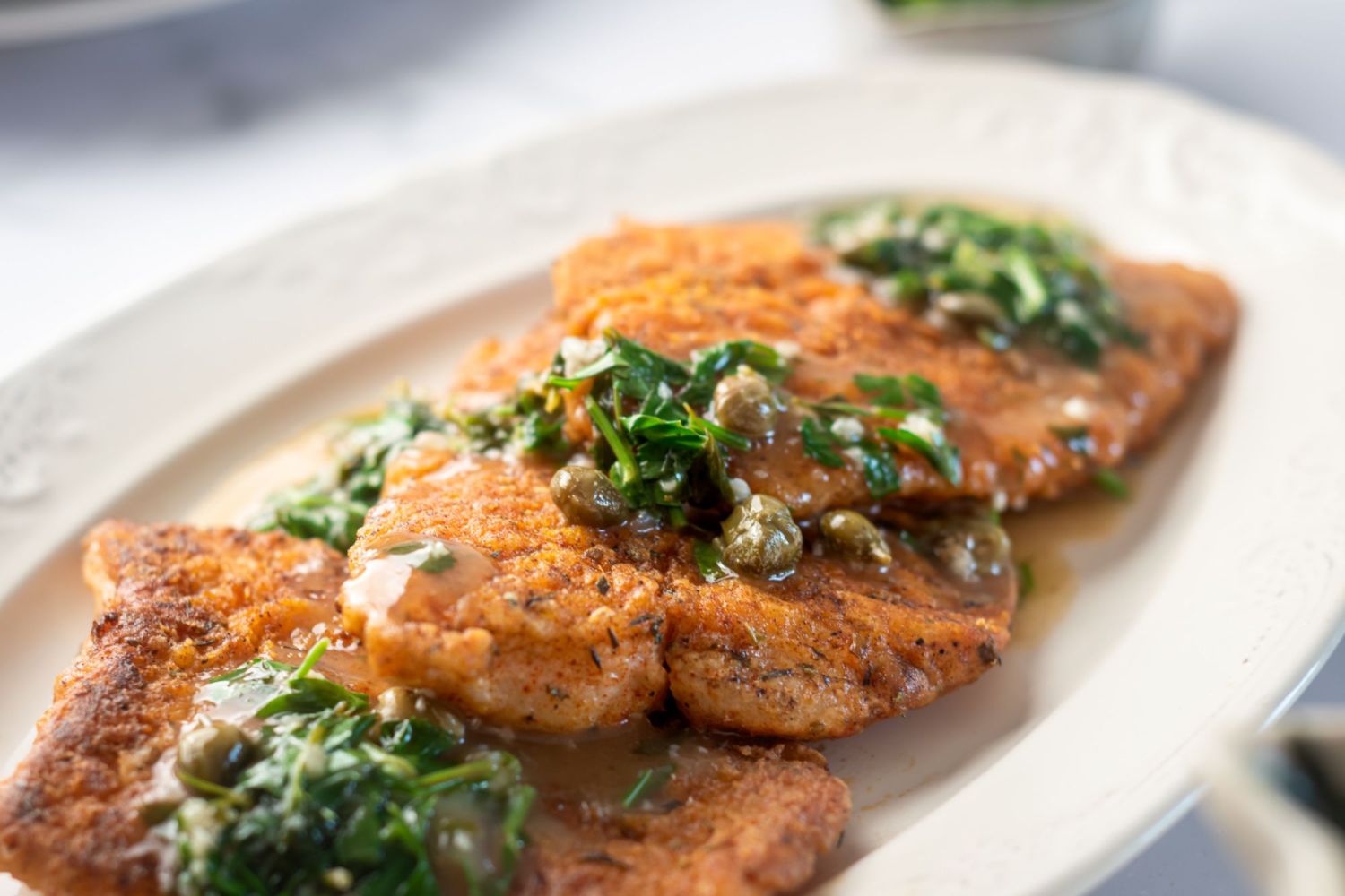 Cod filets that are pan seared with spices served with capers, garlic, lemon, and parsley.