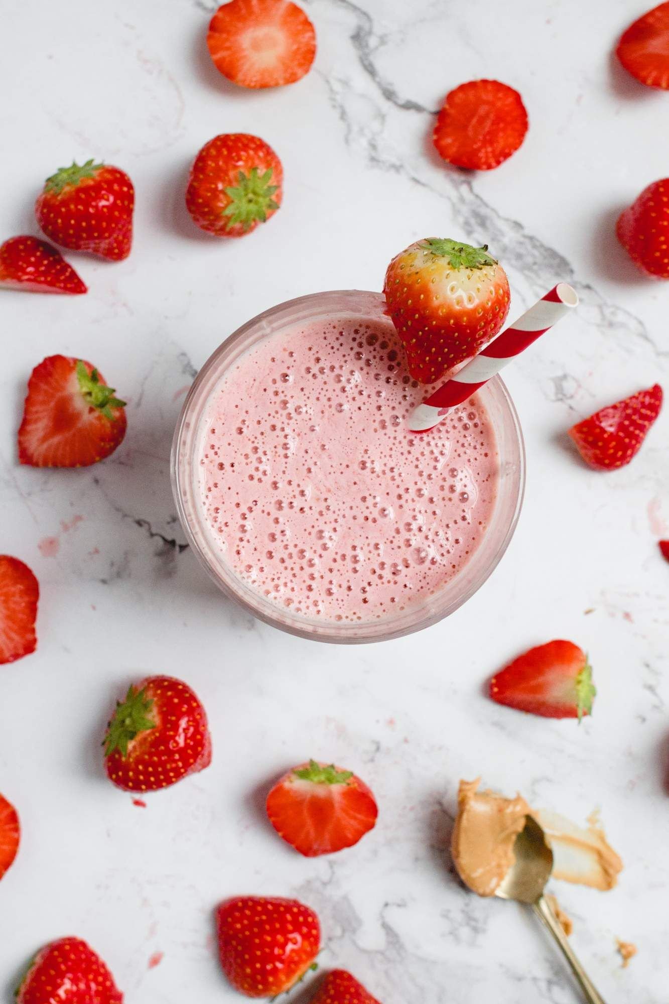 Greek yogurt peanut butter and jelly smoothie with strawberries in a glass.