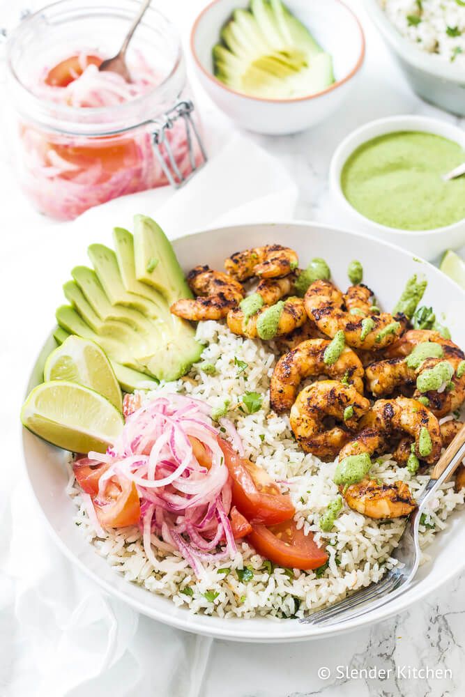 Shrimp and rice bowls with sauteed shrimp, white rice, avocado, tomatoes, onions, and a creamy cilantro sauce.