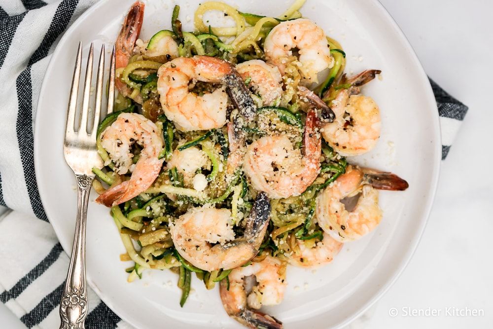 Low Carb Pesto Shrimp with Zucchini Noodles on a plate with fork and napkin.