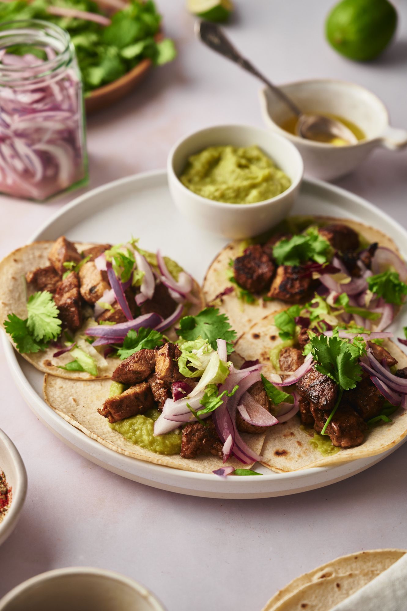 Easy pork tacos with pork tenderloin served on corn tortillas with pickled onions, cilantro, and guacamole.